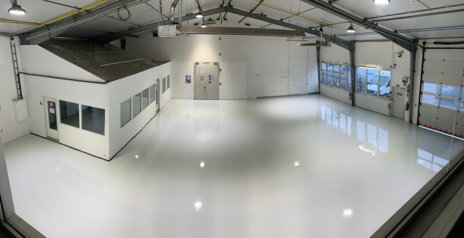 Weitläufiger Hallenboden mit hochglänzender weißer Beschichtung