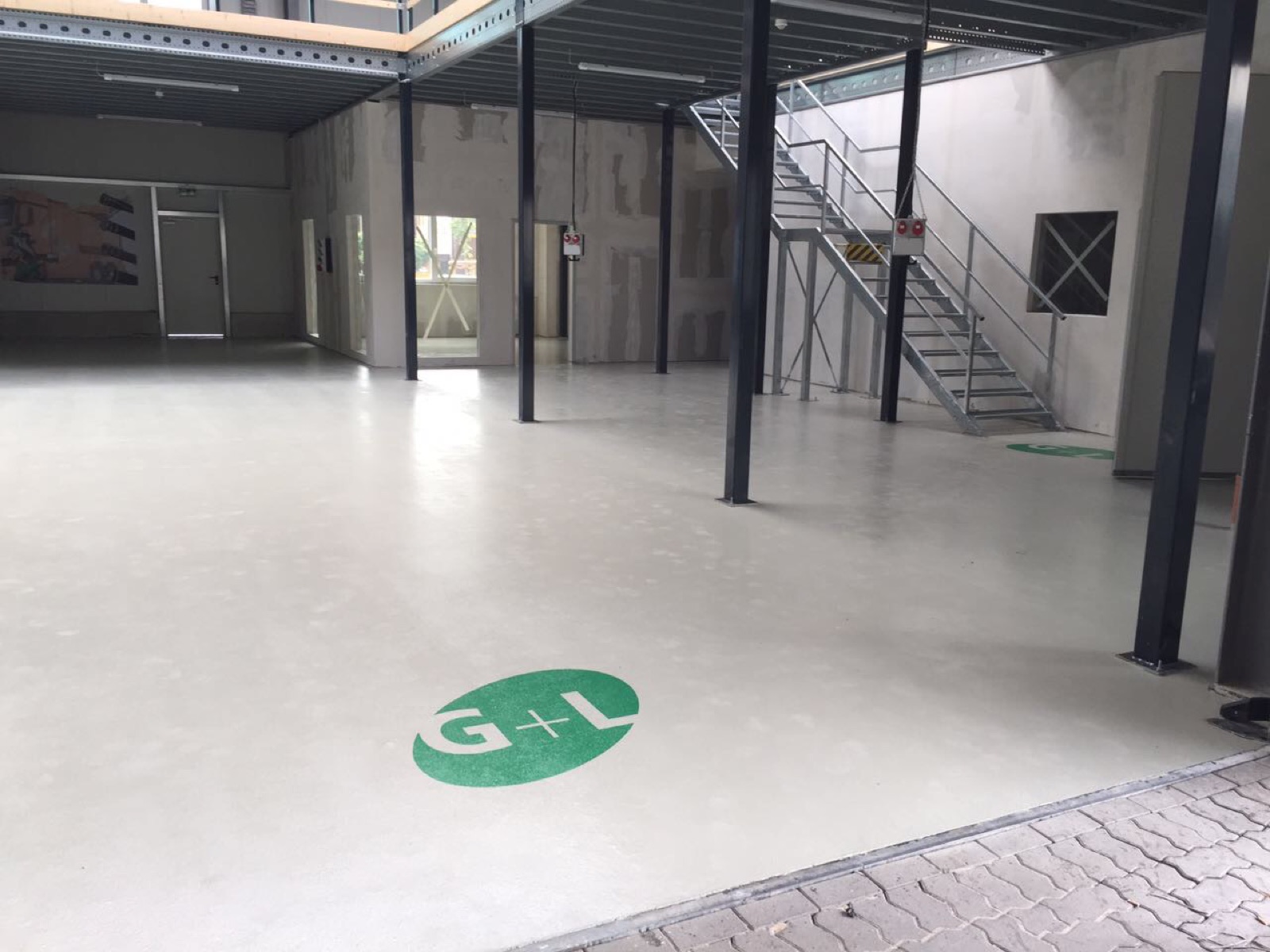 Fertig beschichteter Hallenboden mit eingelassenem G+L Logo