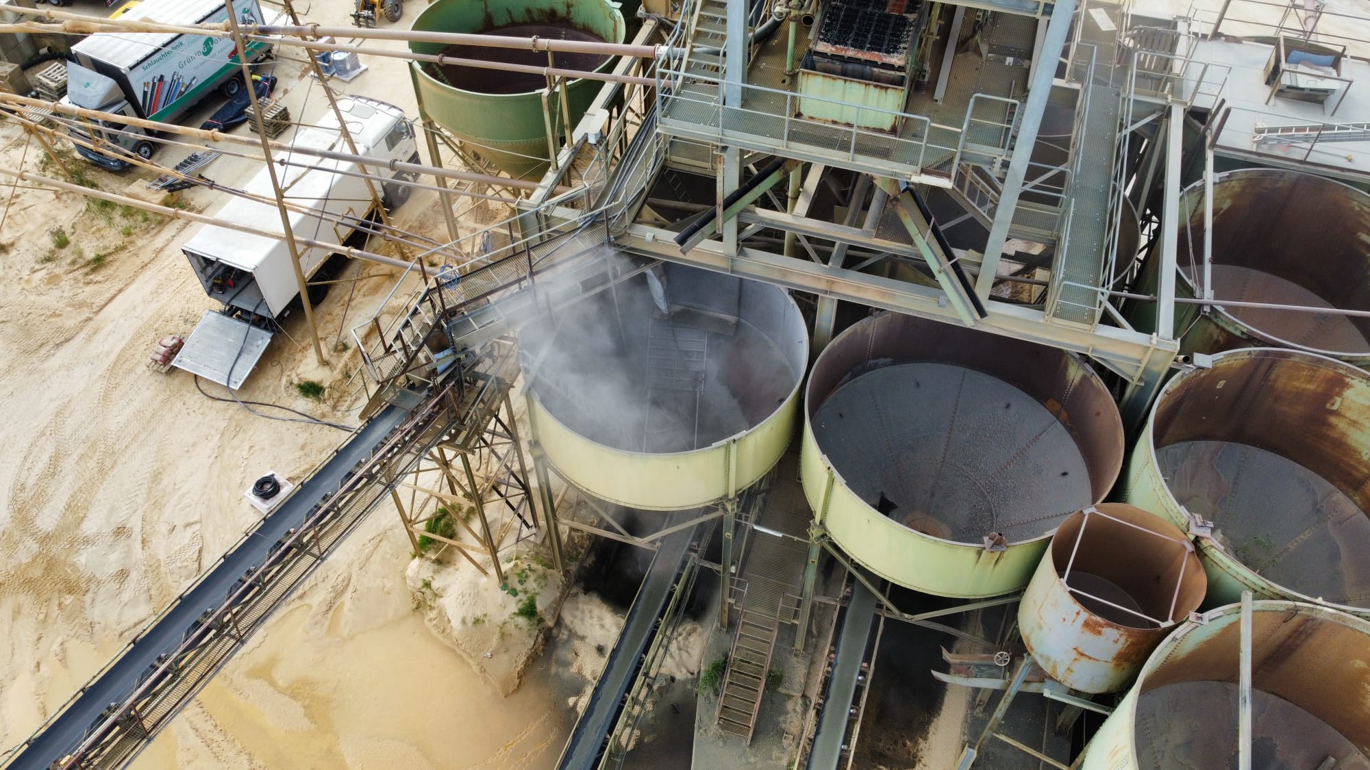 Luftaufnahme einer Anlage mit mehreren Silos und Förderbändern während der Beschichtungsarbeiten