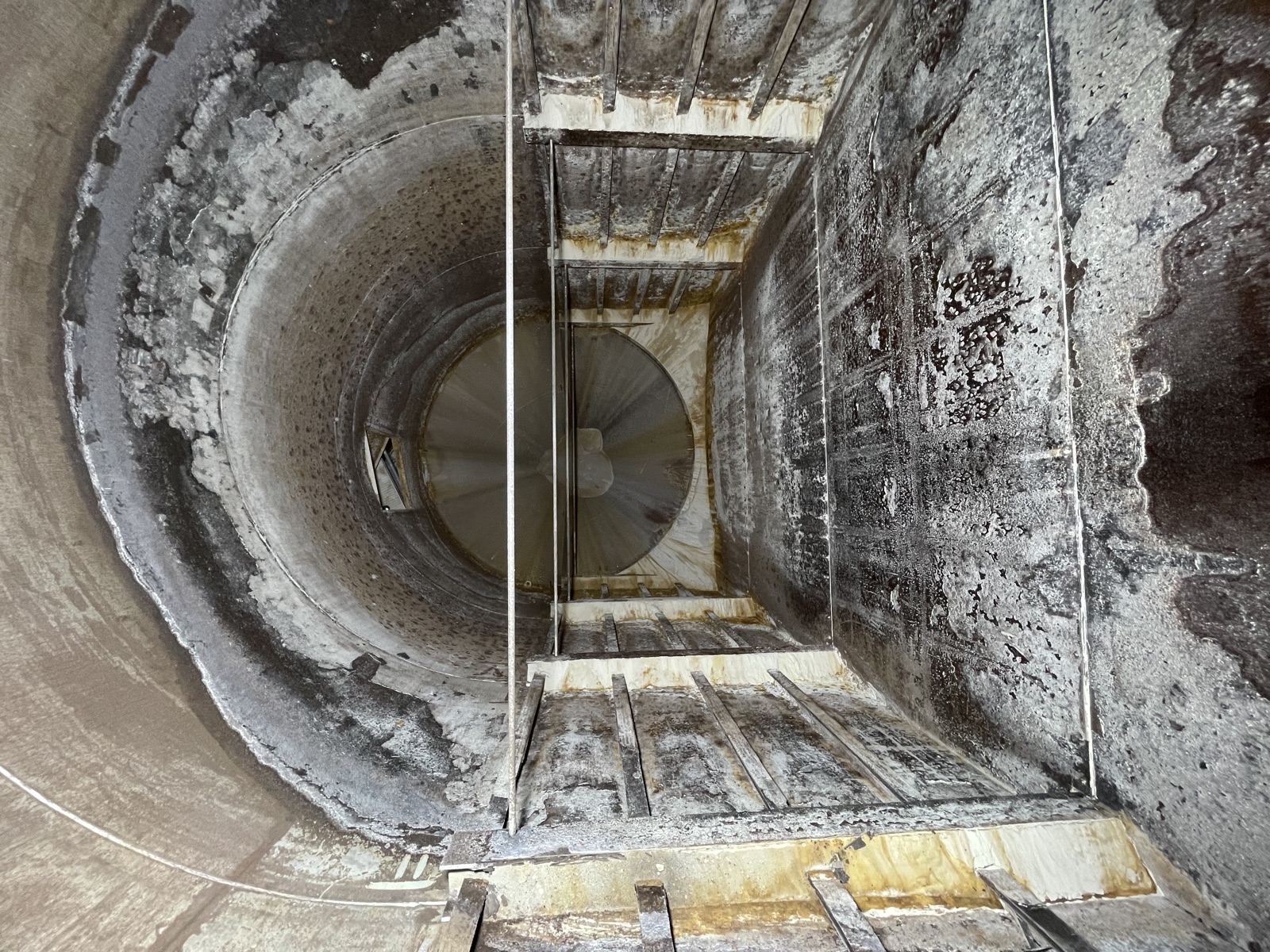 Blick in ein stark verschlissenes Silo mit Trichterauslauf vor der Sanierung